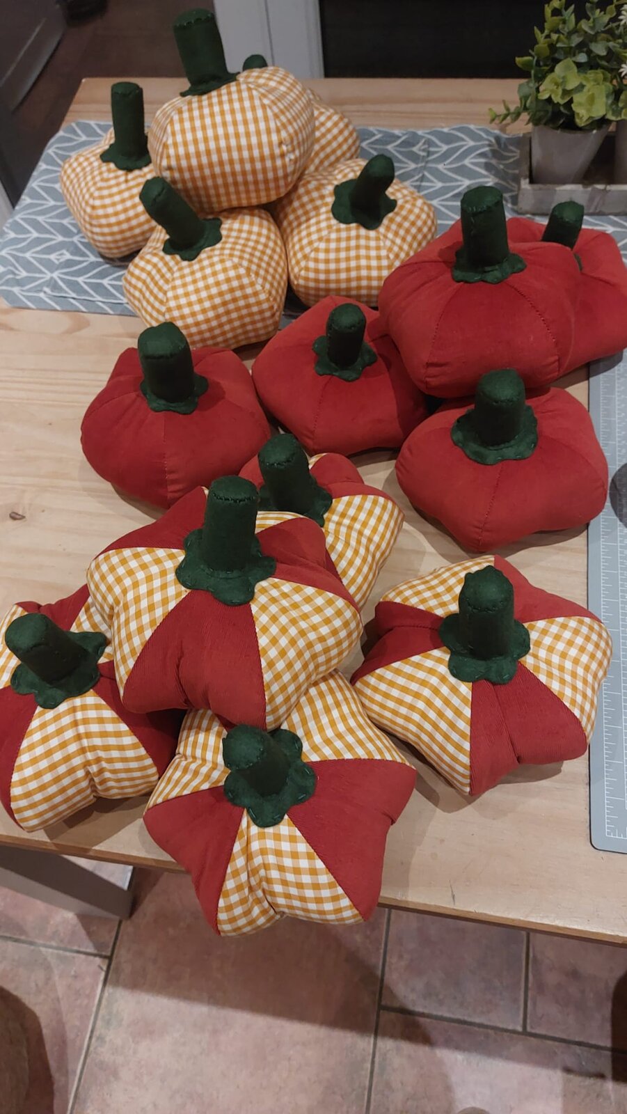 A large pile of finished gingham and corduroy pumpkins